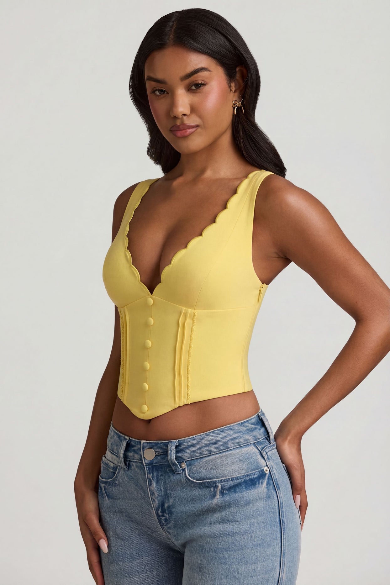 Oh Polly's Yarelis wearing the Lucia Corset Top in Pastel Yellow Stretch Woven fabric perfect for rooftop evenings