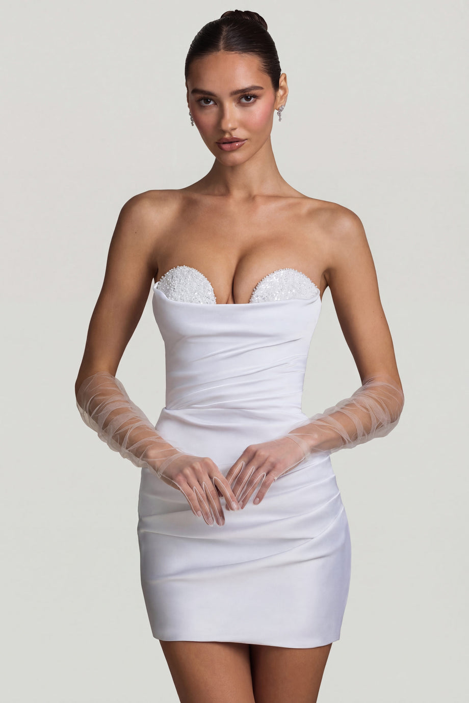Oh Polly's Anna wearing the Tirza Mini Dress in White Satin fabric perfect for holiday festivities