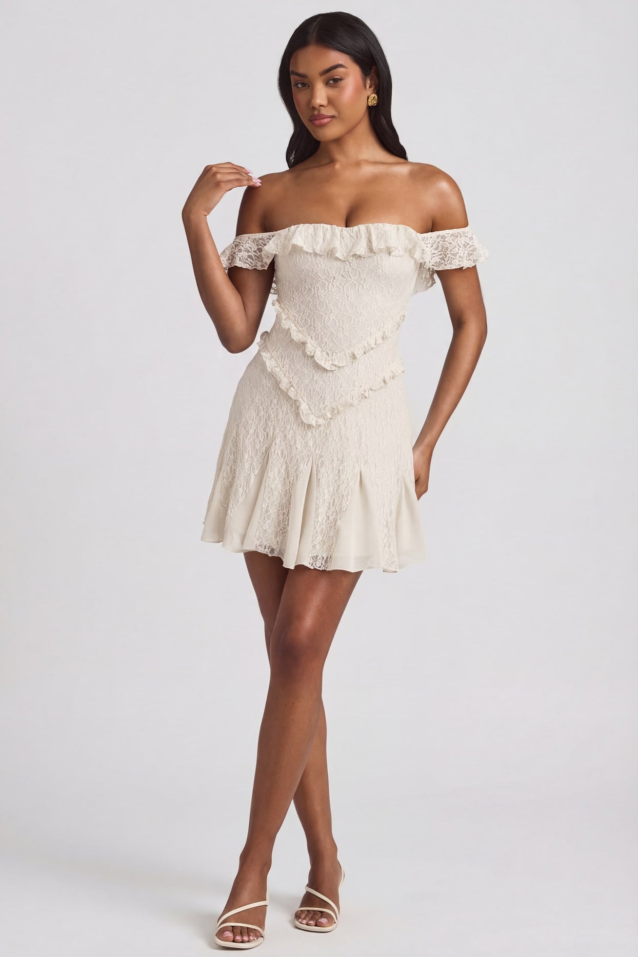 Oh Polly's Yarelis wearing the Nahida Mini Dress in Ivory Stretch Lace fabric perfect for summer garden parties