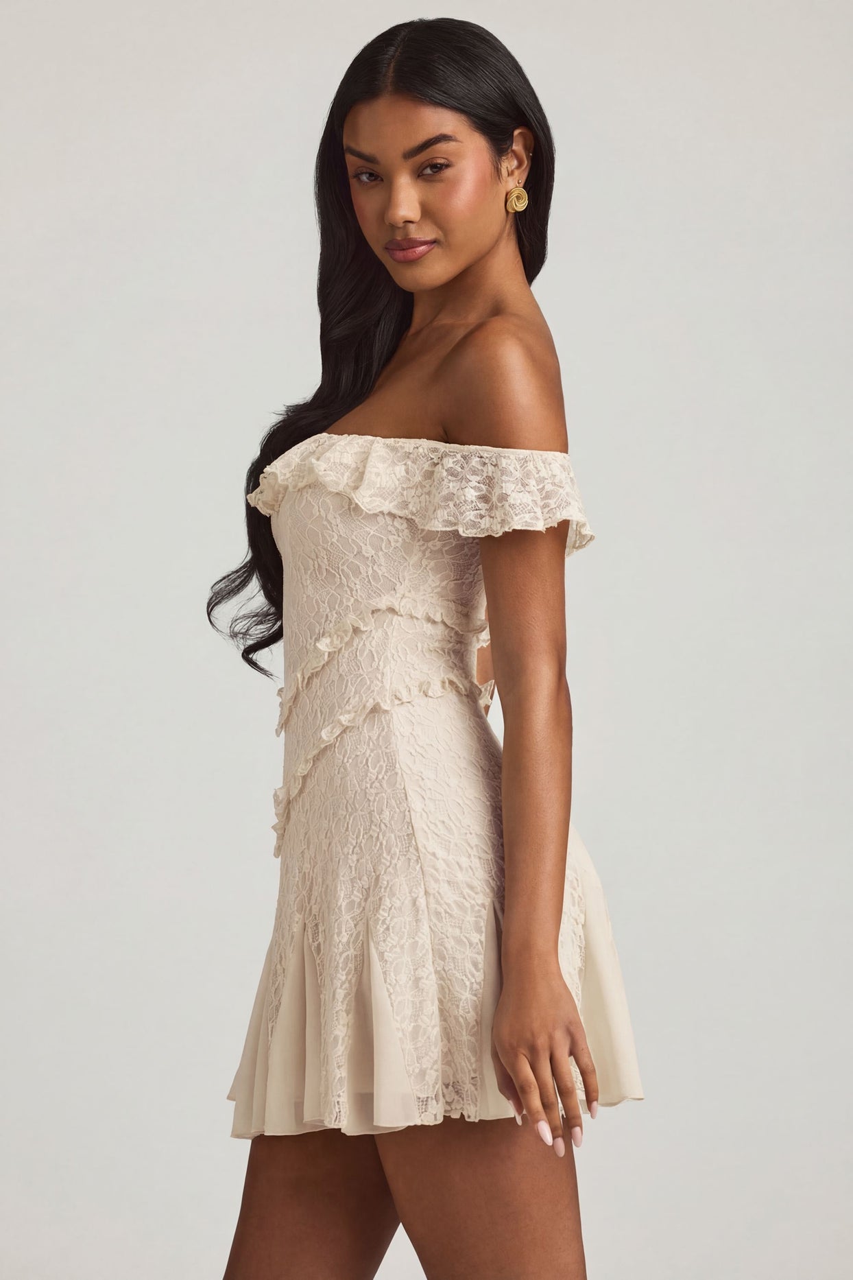 Oh Polly's Yarelis wearing the Nahida Mini Dress in Ivory Stretch Lace fabric perfect for summer garden parties