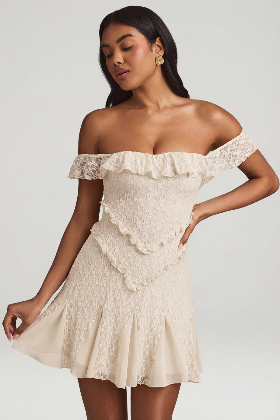 Oh Polly's Yarelis wearing the Nahida Mini Dress in Ivory Stretch Lace fabric perfect for cocktail hour gatherings
