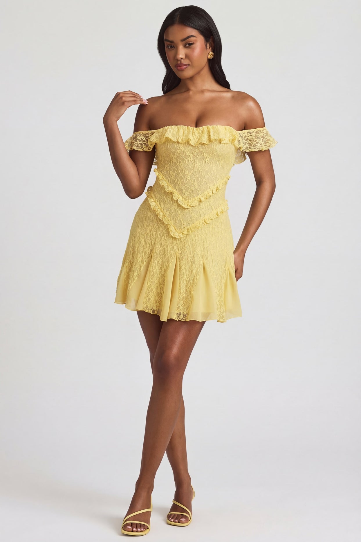 Oh Polly's Yarelis wearing the Nahida Mini Dress in Pastel Yellow Stretch Lace fabric perfect for summer garden parties