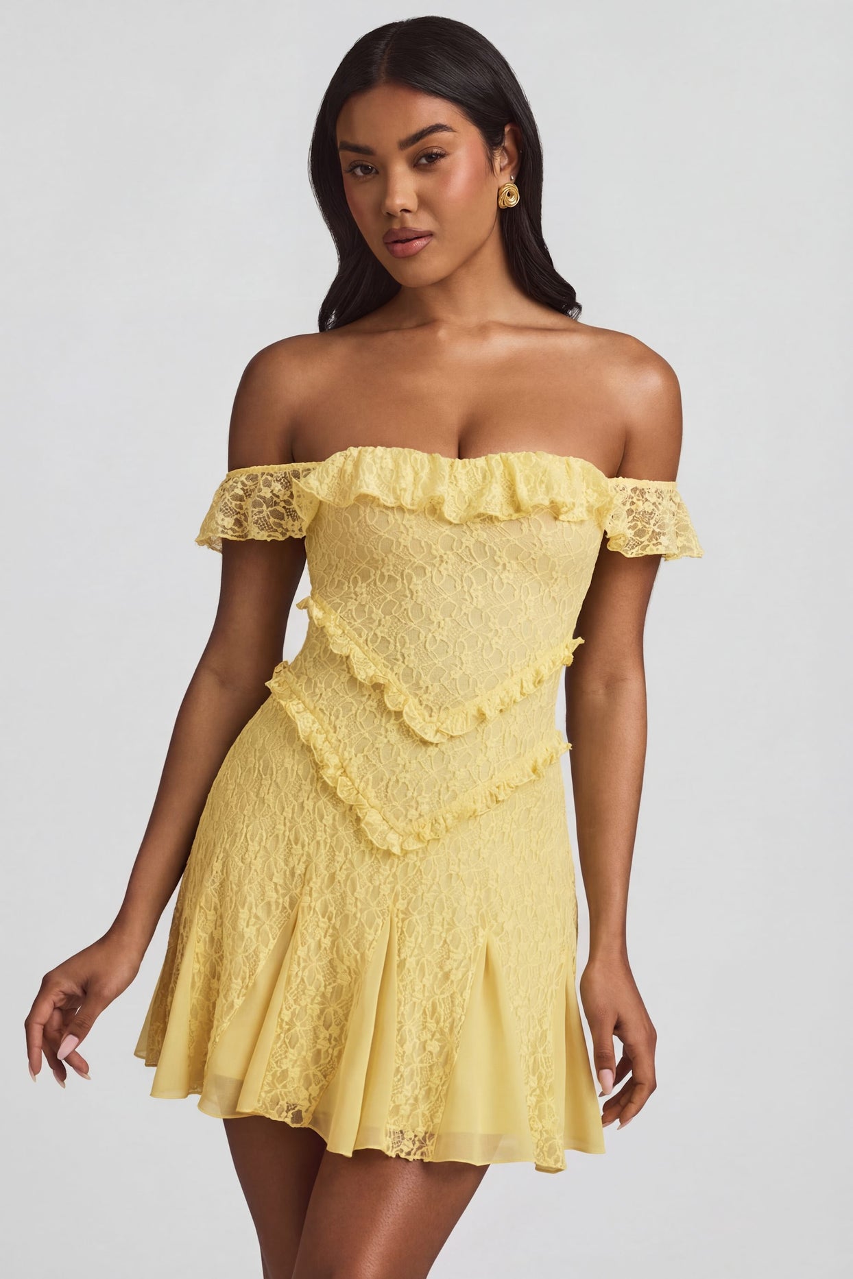 Oh Polly's Yarelis wearing the Nahida Mini Dress in Pastel Yellow Stretch Lace fabric perfect for rooftop cocktails