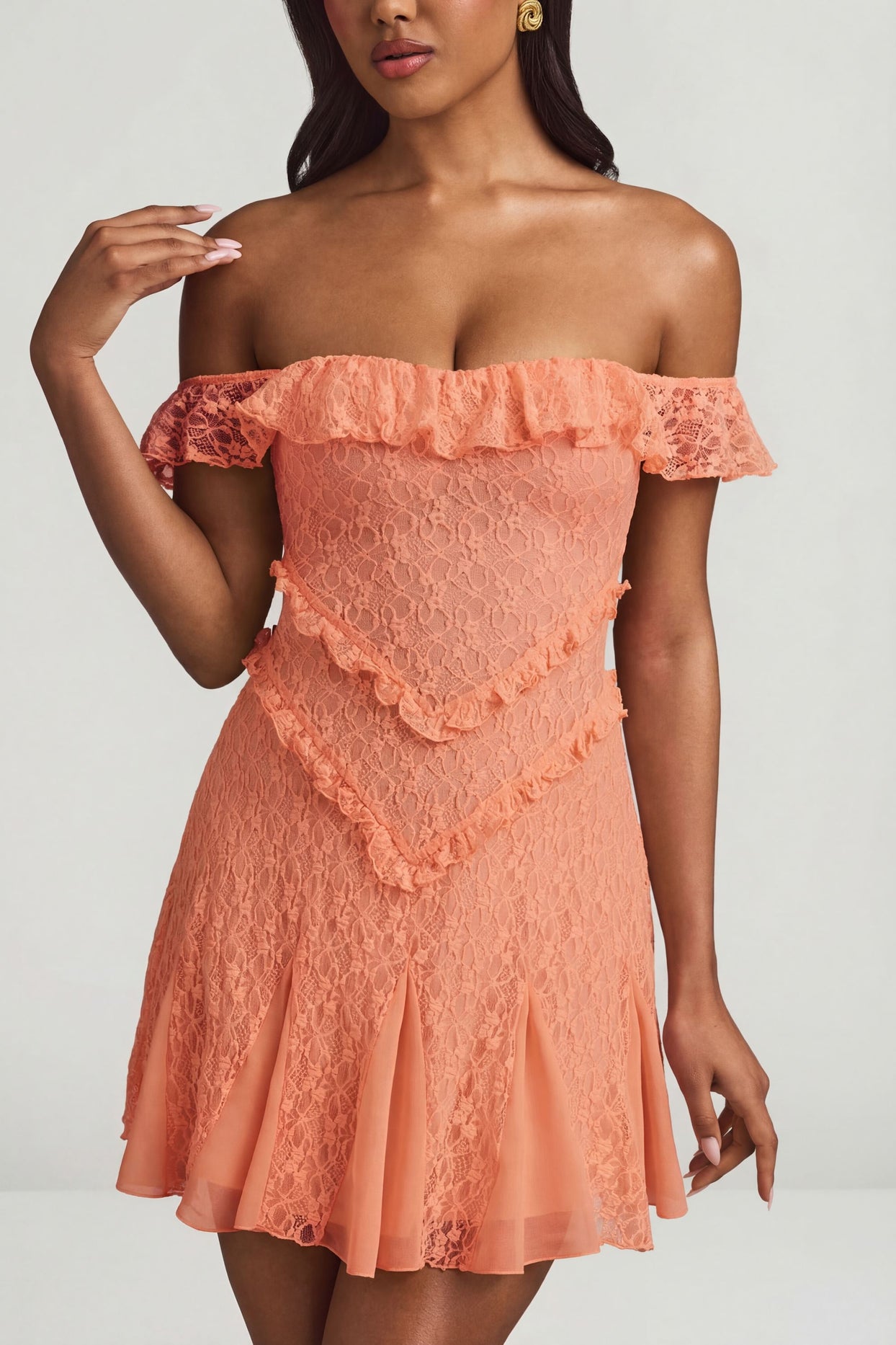 Oh Polly's Yarelis wearing the Nahida Mini Dress in Peach Stretch Lace fabric perfect for beachside dinners