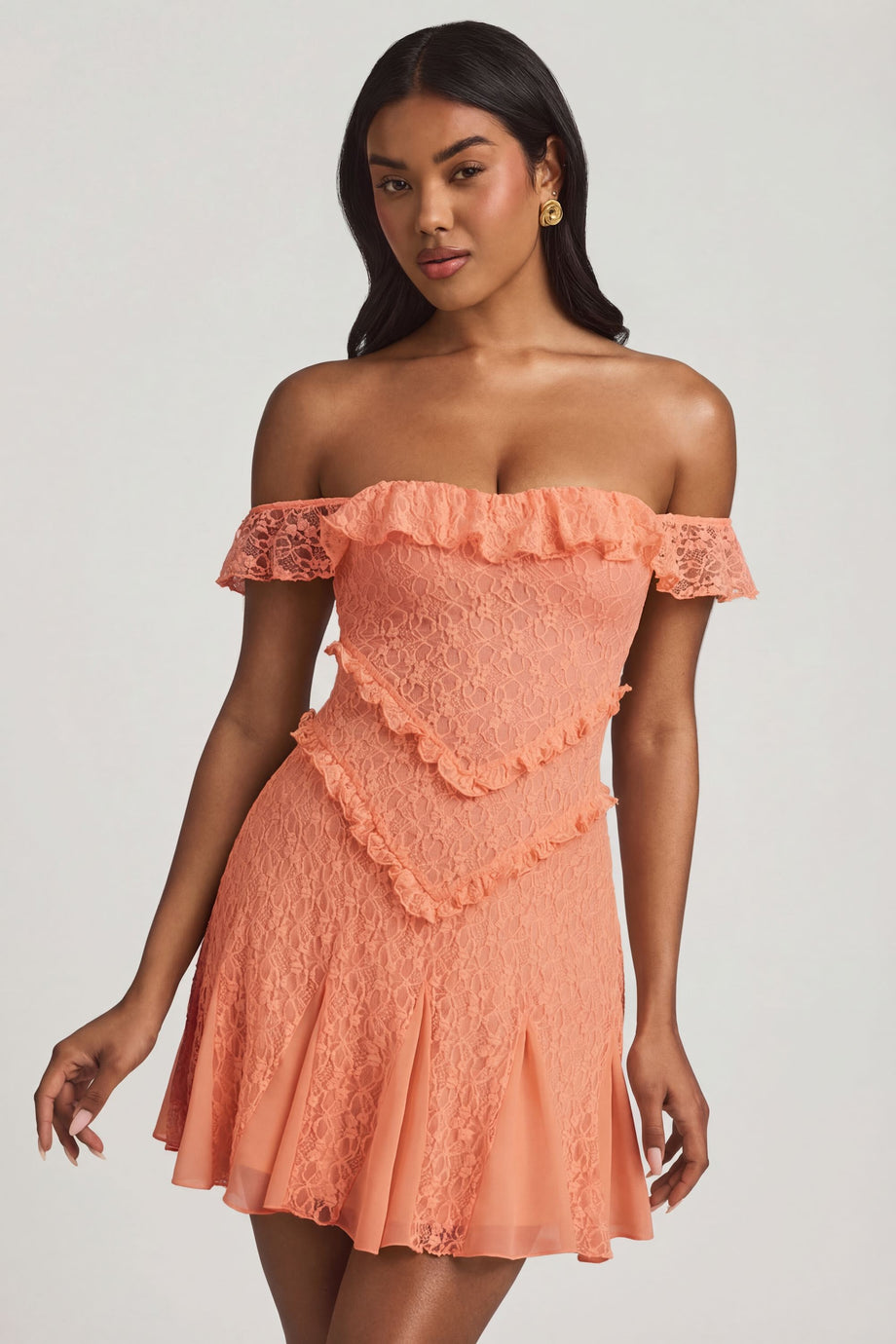 Oh Polly's Yarelis wearing the Nahida Mini Dress in Peach Stretch Lace fabric perfect for birthday celebrations