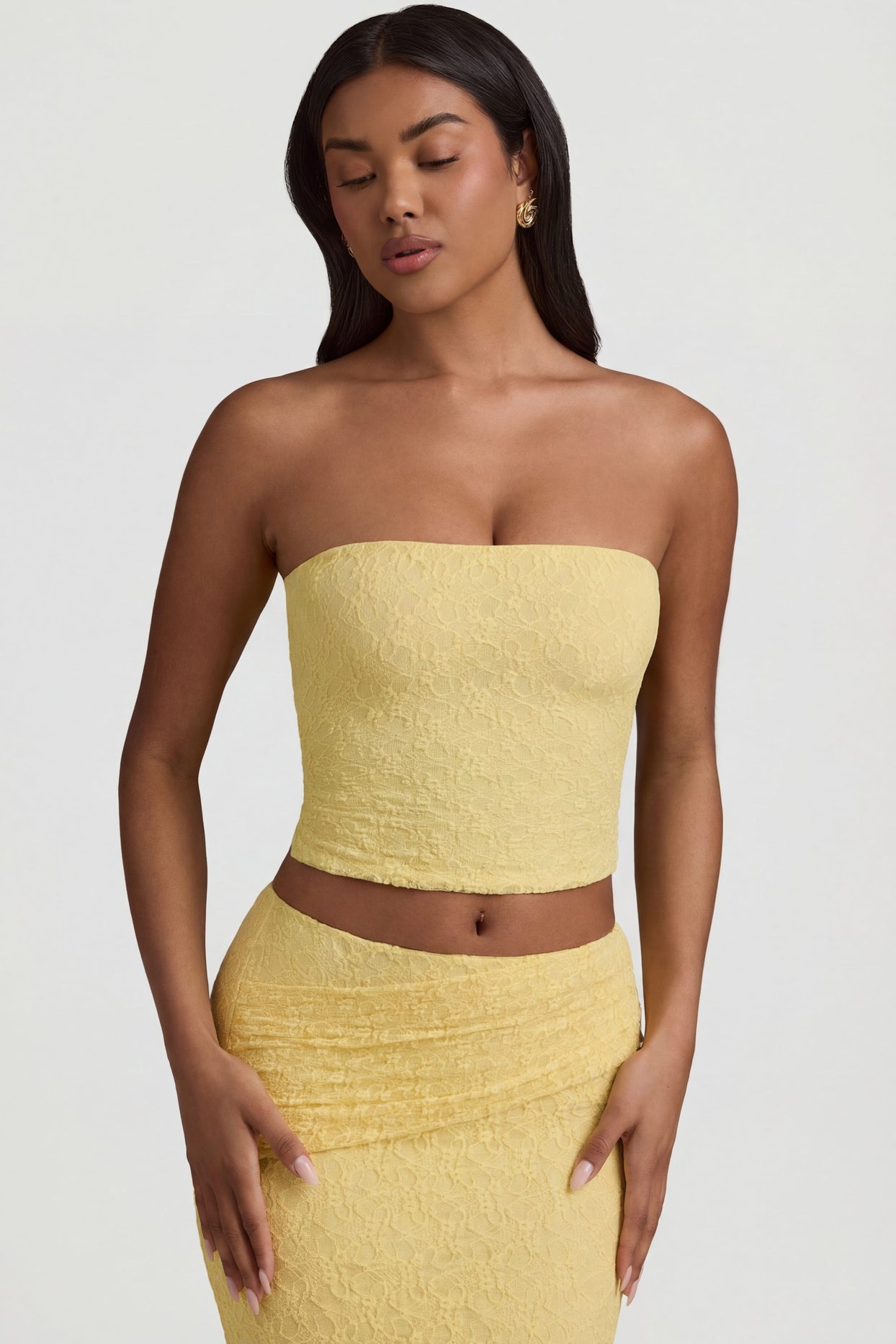 Oh Polly's Yarelis wearing the Tamia Full Top in Pastel Yellow Stretch Lace fabric perfect for rooftop gatherings