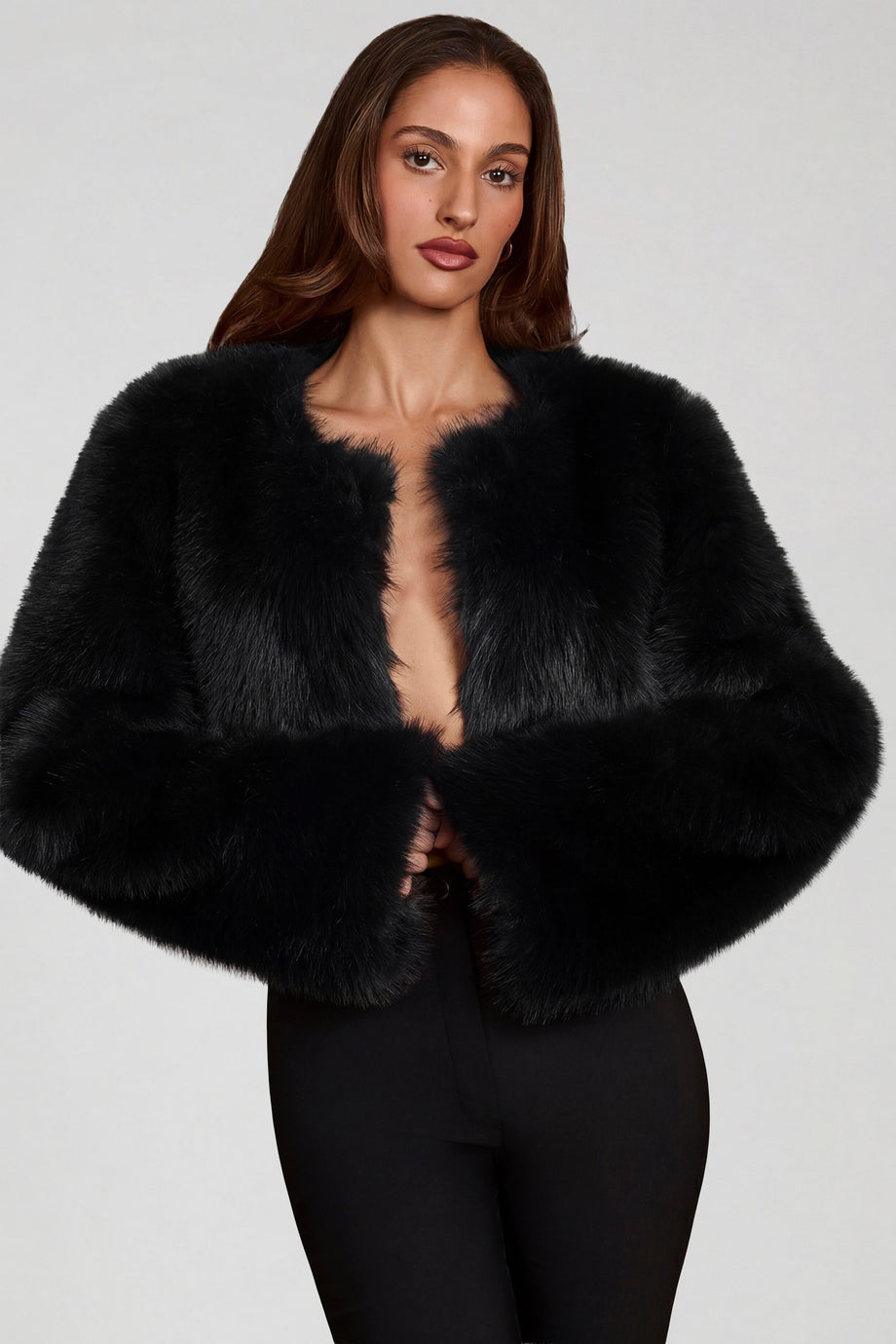 Oh Polly model Yasmin wearing the Almerinda Coat in Black Faux Fur fabric perfect for evening dinner dates