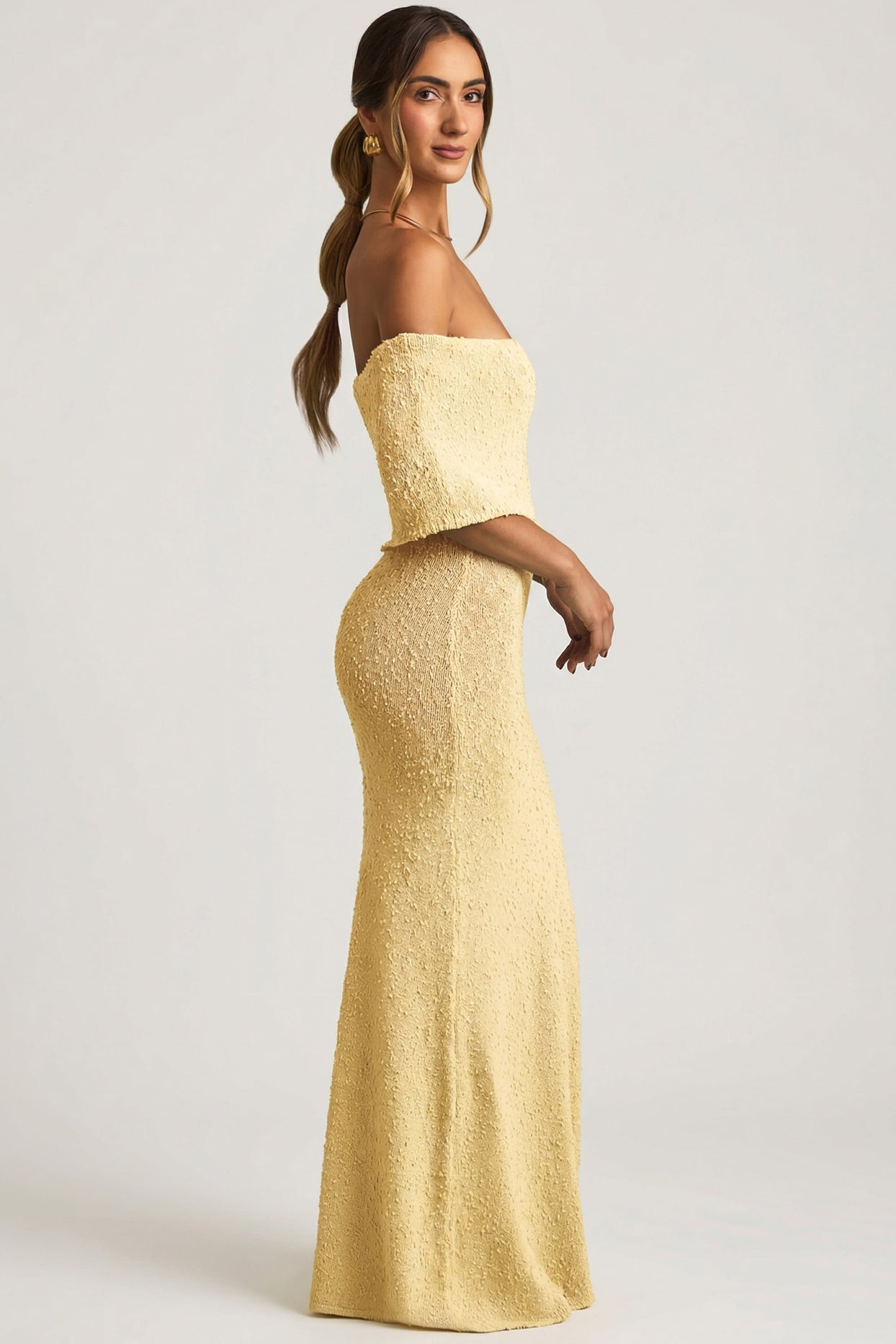 Oh Polly model Priscilla wearing the Naia Maxi Dress in Yellow Boucle Knit fabric perfect for rooftop evenings