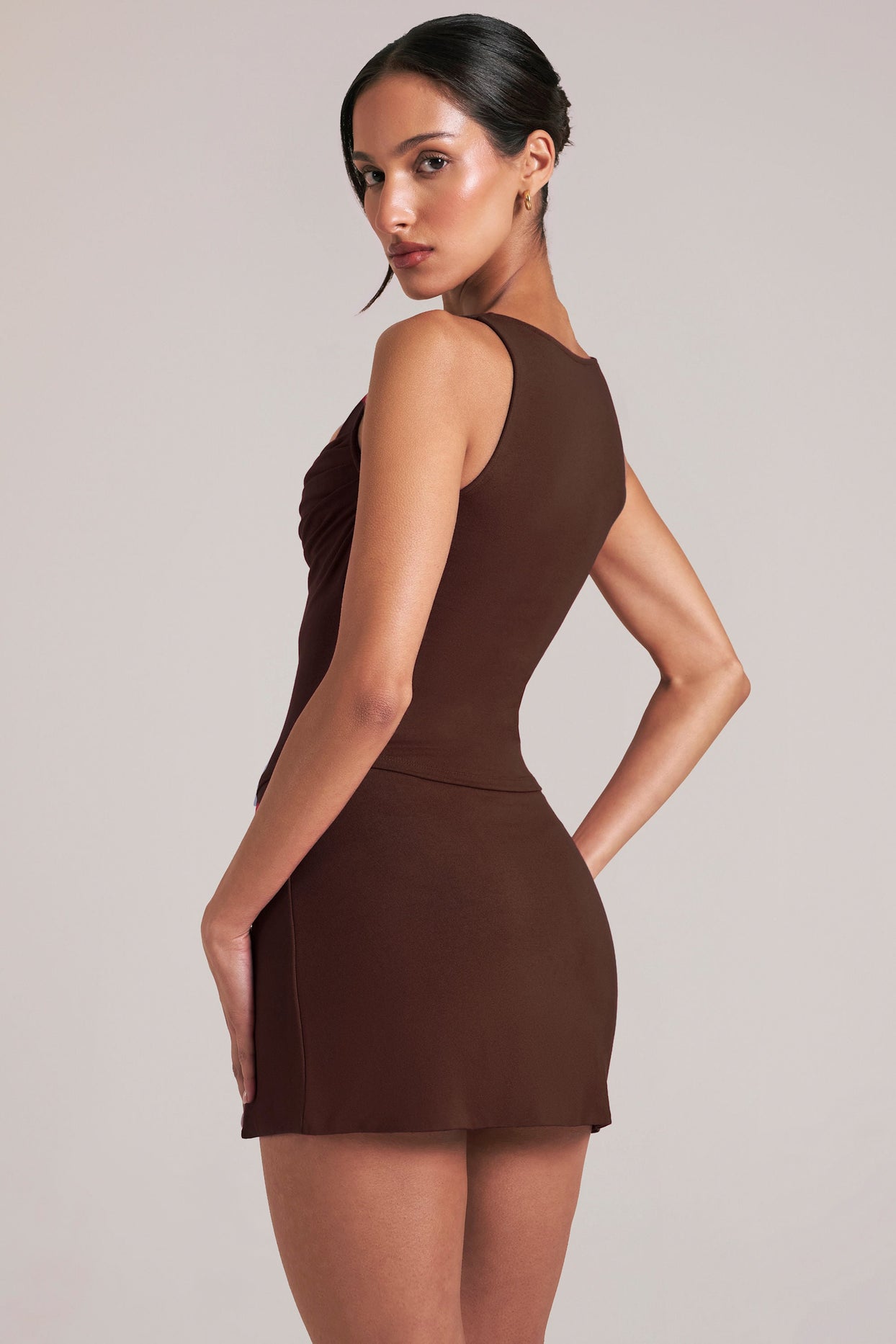 Oh Polly model Yasmin wearing the Tula Mini Skirt in Chocolate Brown Modal fabric perfect for holiday dinners