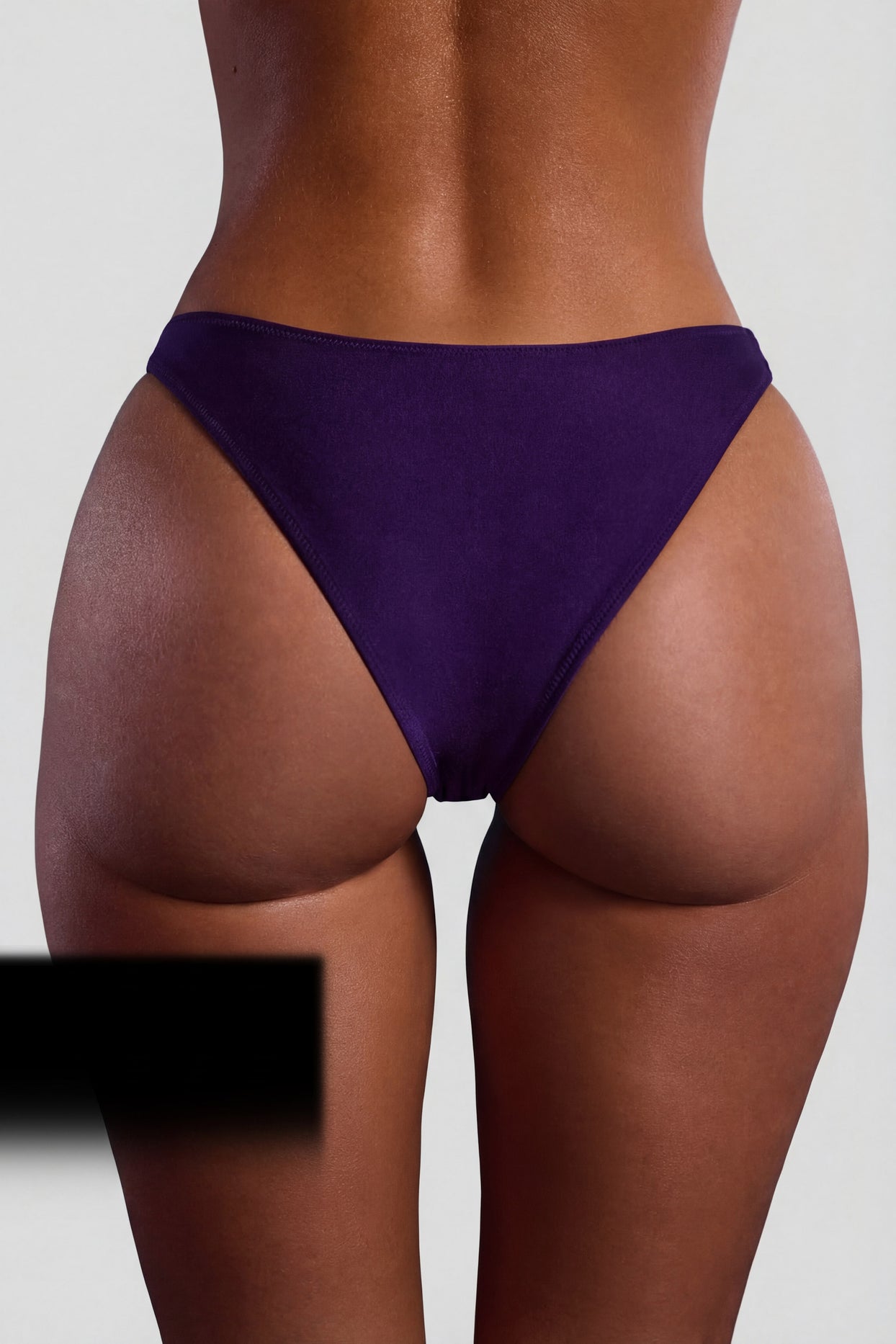 Oh Polly Swim's Sierra Skye wearing the Palau Bikini Bottoms in Deep Purple fabric perfect for tropical beach getaways