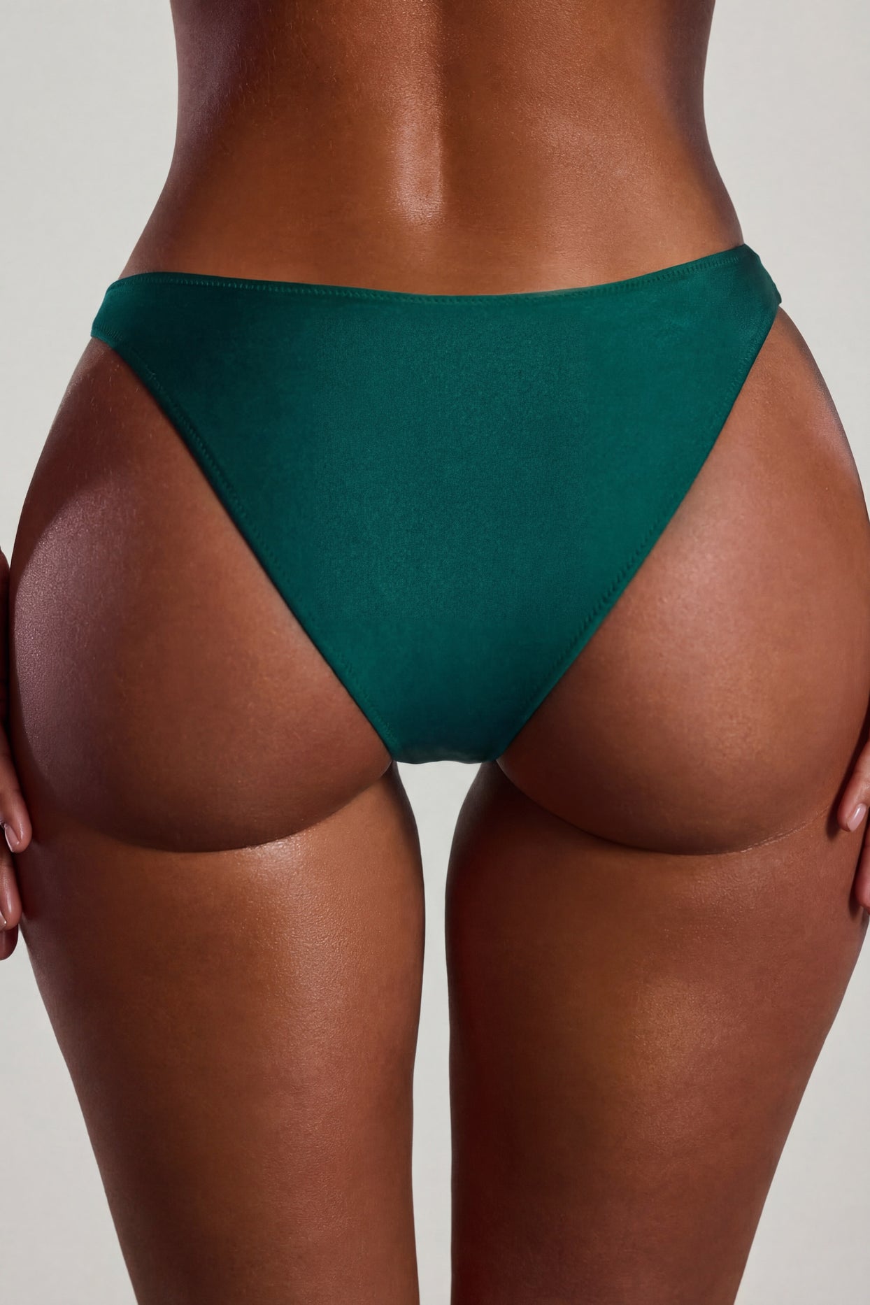 Oh Polly Swim's Sierra Skye wearing the Palau Bikini Bottoms in Jade Green fabric perfect for tropical beach getaways