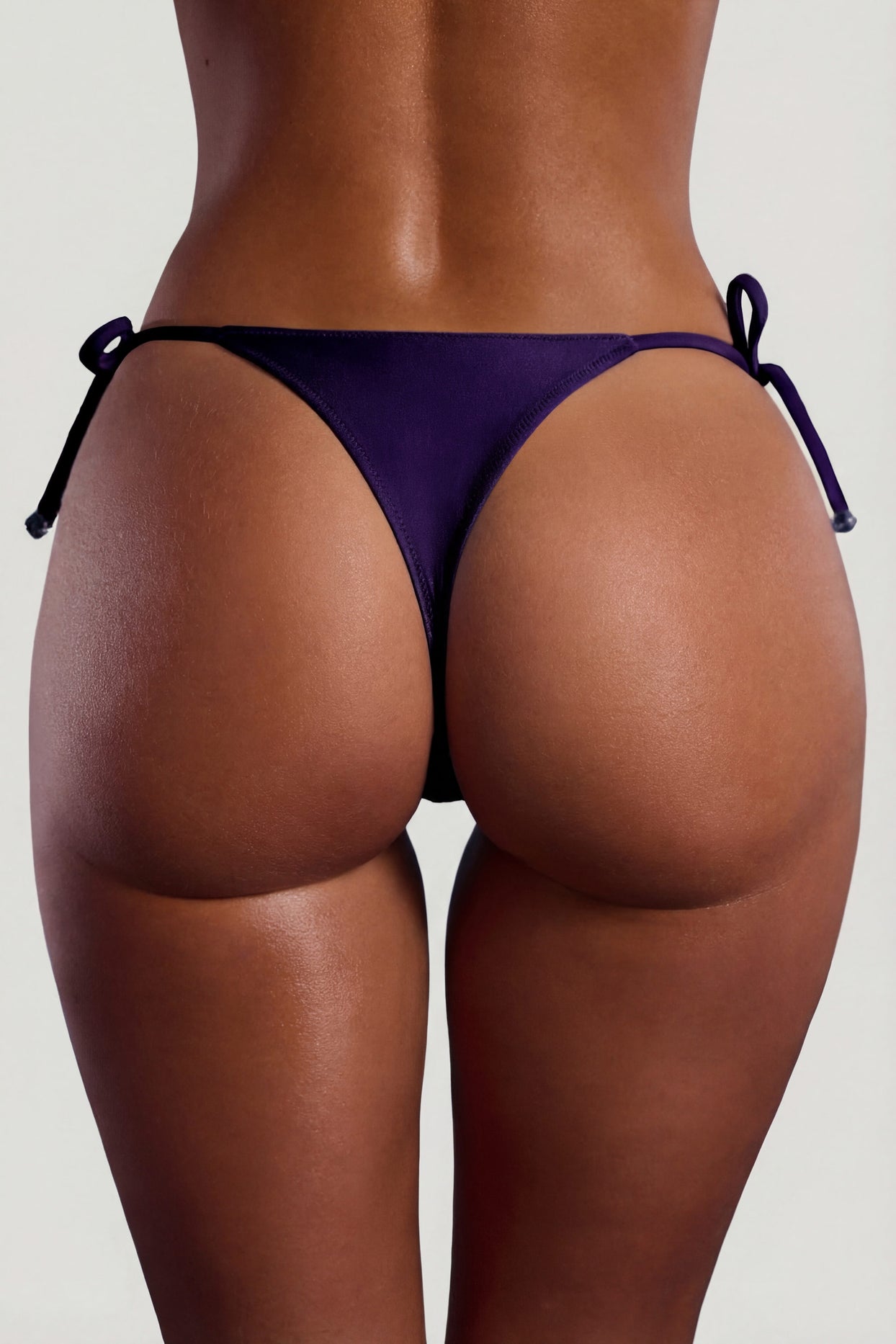 Oh Polly Swim's Sierra Skye wearing the Bocas Bikini Bottoms in Deep Purple fabric perfect for tropical vacations