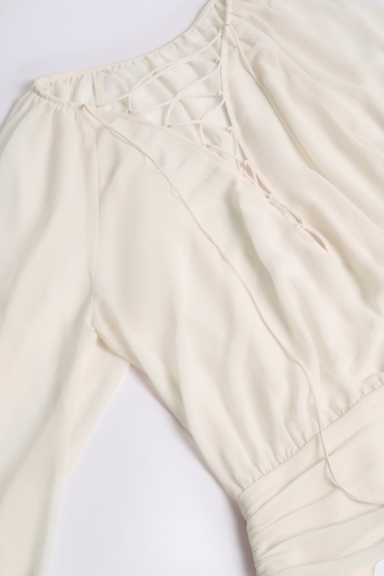 فستان عاجي بأكمام منفوخة وربطة عنق