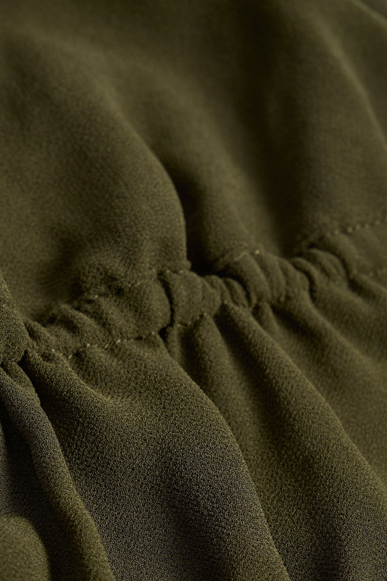 بلوزة قصيرة شبه شفافة مكشكشة، بفتحة رقبة دائرية، بلون كاكي داكن