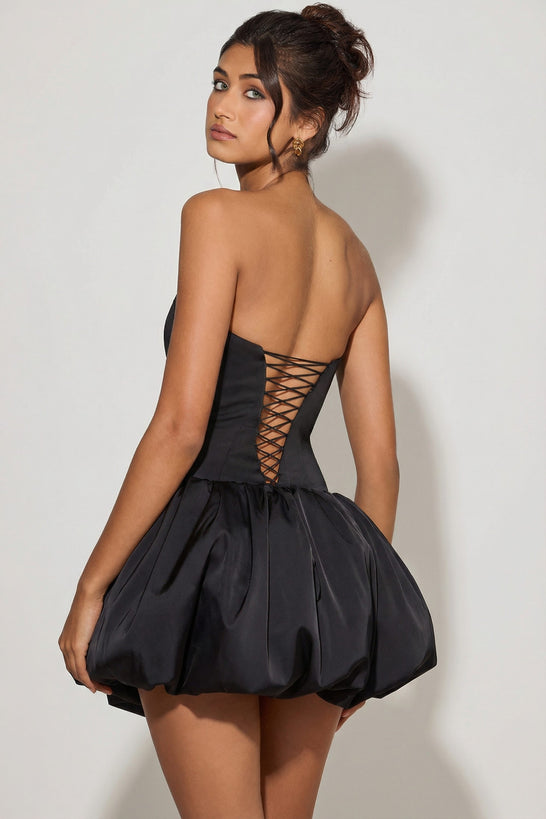 Oh Polly's Meeya wearing the Minerva Mini Dress in Black Satin fabric perfect for holiday celebrations