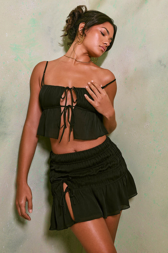 تنورة قصيرة بخصر متوسط الطول وفتحة عالية باللون الأسود